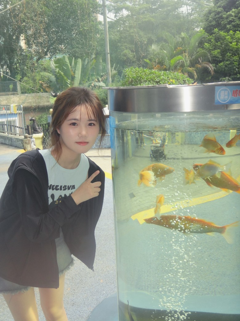 曾琪玲在鱼缸边比耶